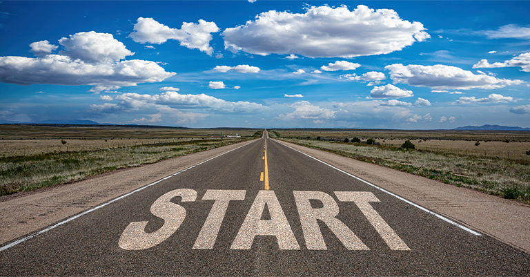 TextAnalysis_5 • Andrew Roche AI Long road stretching into the horizon with the word "START" written on the asphalt under a bright, cloud-filled sky.